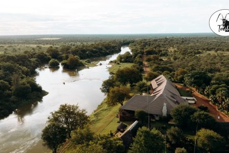 Aerial view of Tolile Lodge on the river, with the Tolile Lodge crest